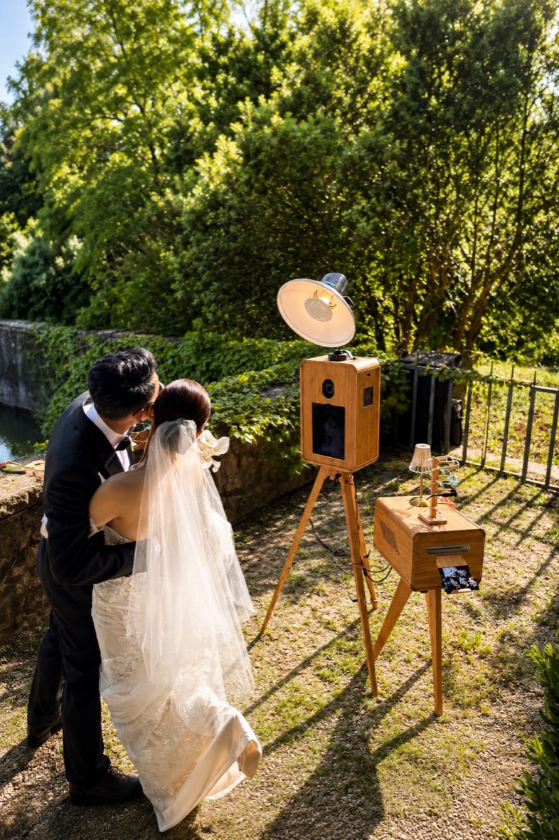Los novios junto al fotomatón de madera en el jardín de La Baronia, Barcelona