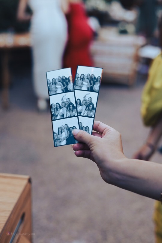 Manos sosteniendo dos tiras de fotos en blanco y negro recién impresas en el fotomatón