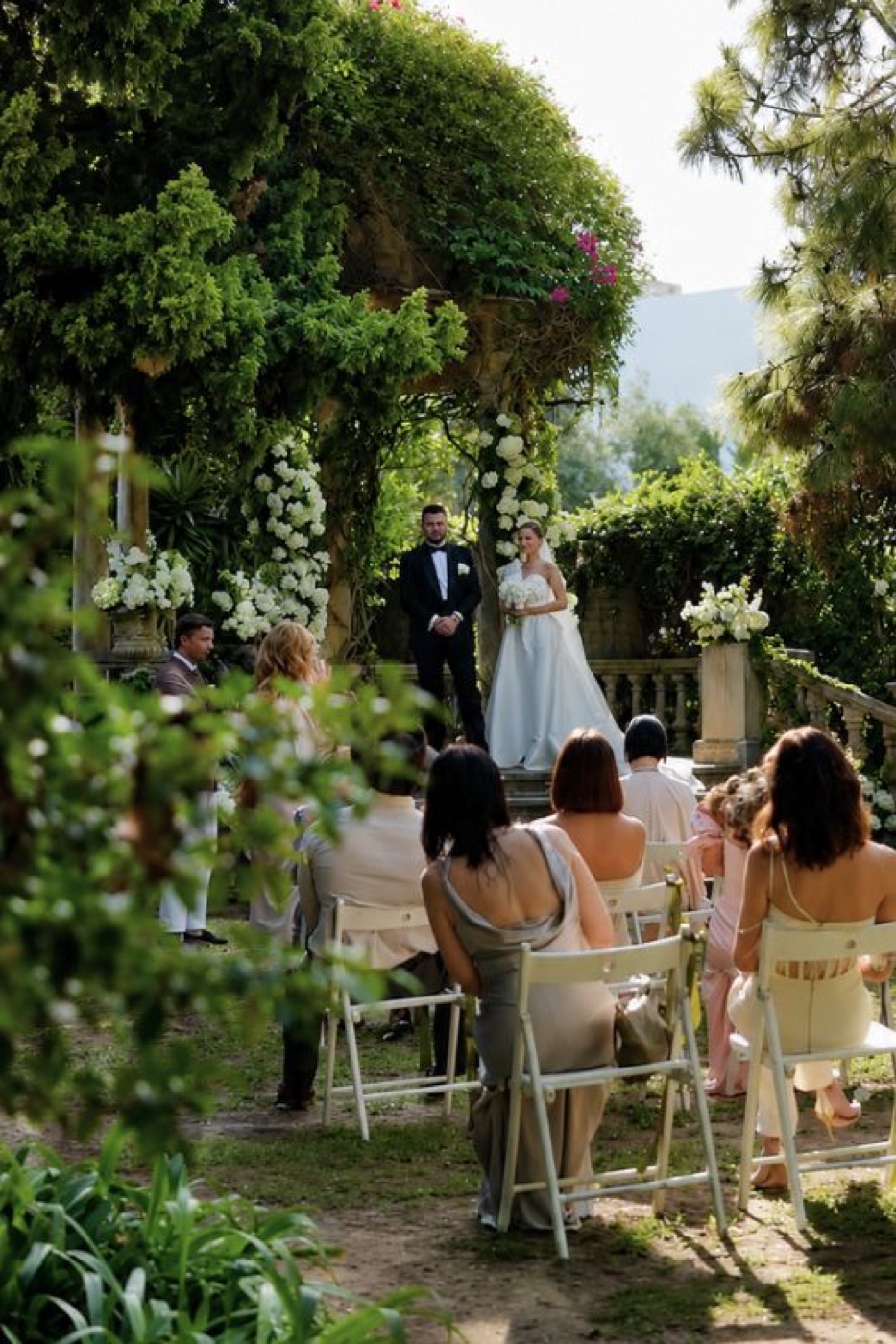 Ceremonia de boda de Irina y Vladislav ante un arco floral en el jardín de Casa Santonja (Alicante)